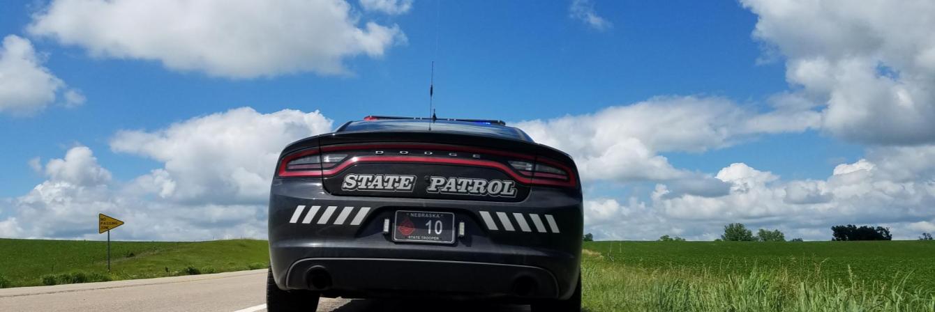 back of state patrol car and blue skies