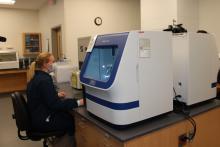 examiner using lab equipment and computer