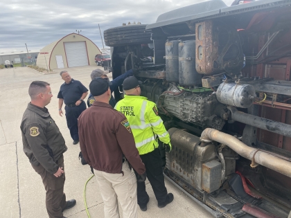 Troopers from several states inspecting a rolled over truck