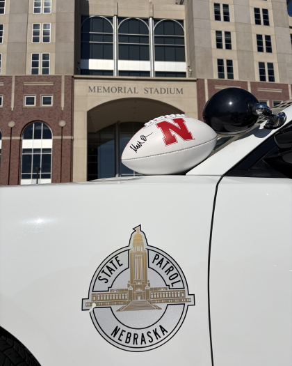 Matt Rhule autographed football sitting on a Nebraska State Patrol cruiser outside Memorial Stadium